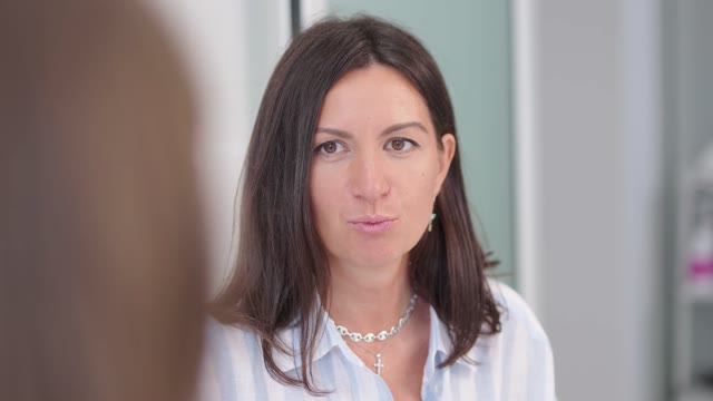 Стоматолог разговаривает с пациентом в кабинете